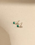 sterling silver bezel studs with 4mm emerald stones on a light background