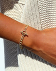 Model wearing 14k gold fill Alexandra Toggle Bracelet in the sunlight. This bracelet features the Alexandra chain with the toggle link to connect it together.