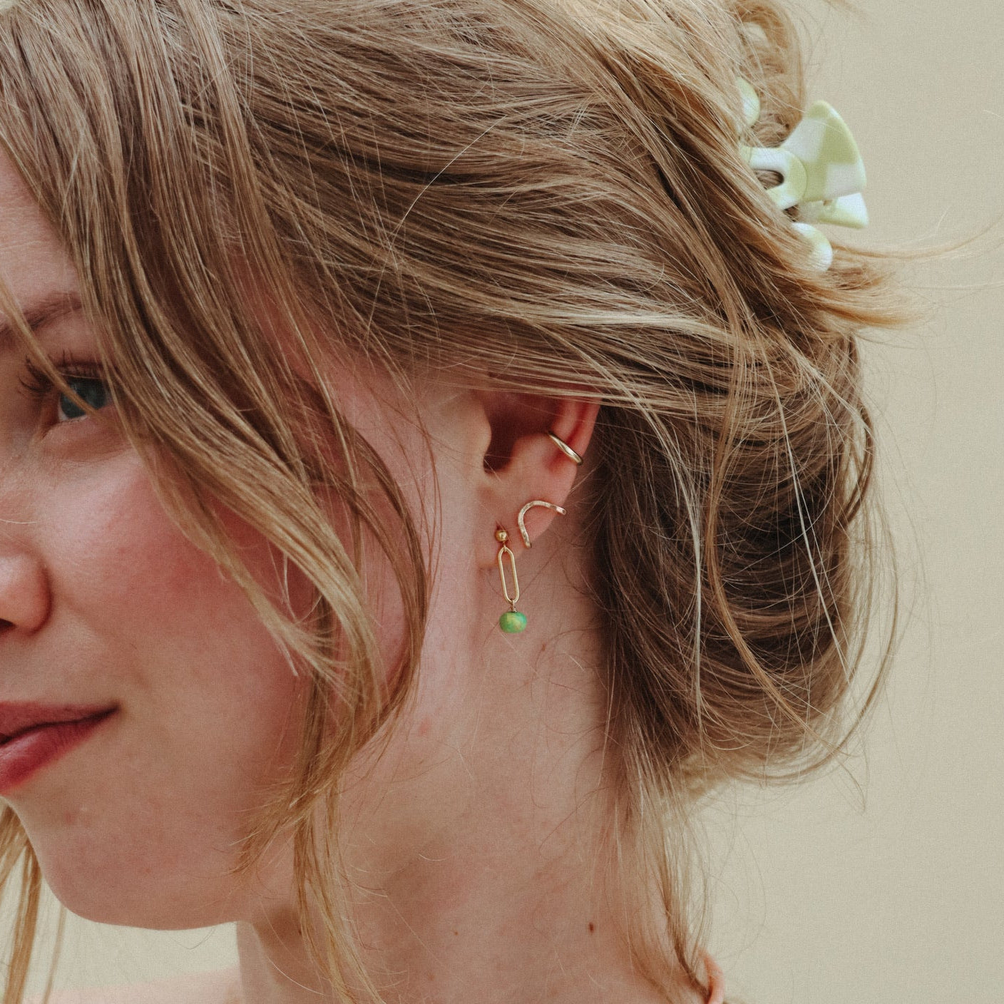 model wearing 14k gold fill stud earrings with turquoise drops paired with other 14k gold fill studs and ear cuff