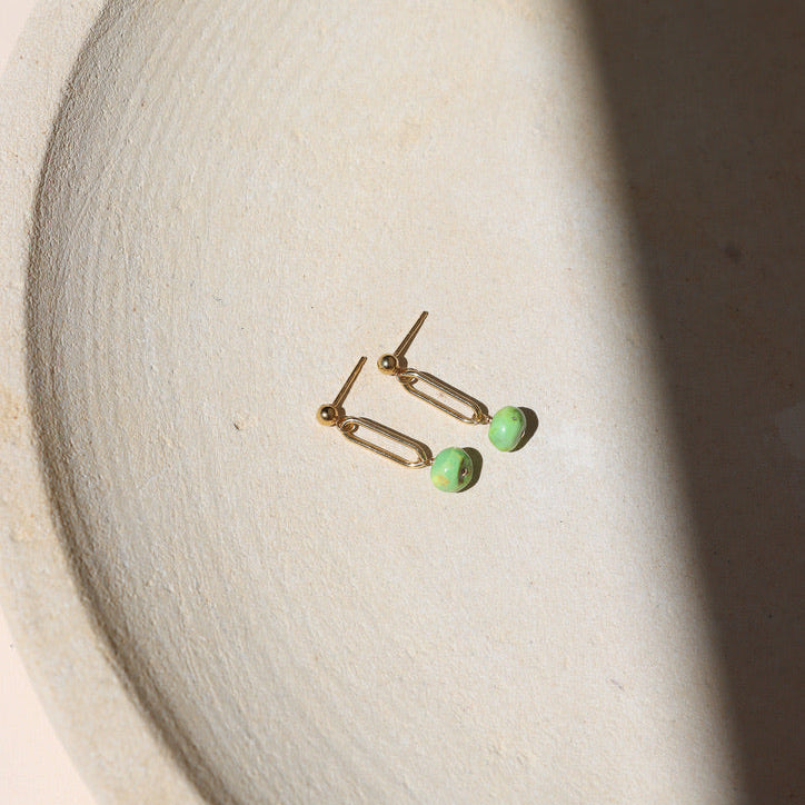 14k gold fill stud earrings with turquoise bead drops on a light dish