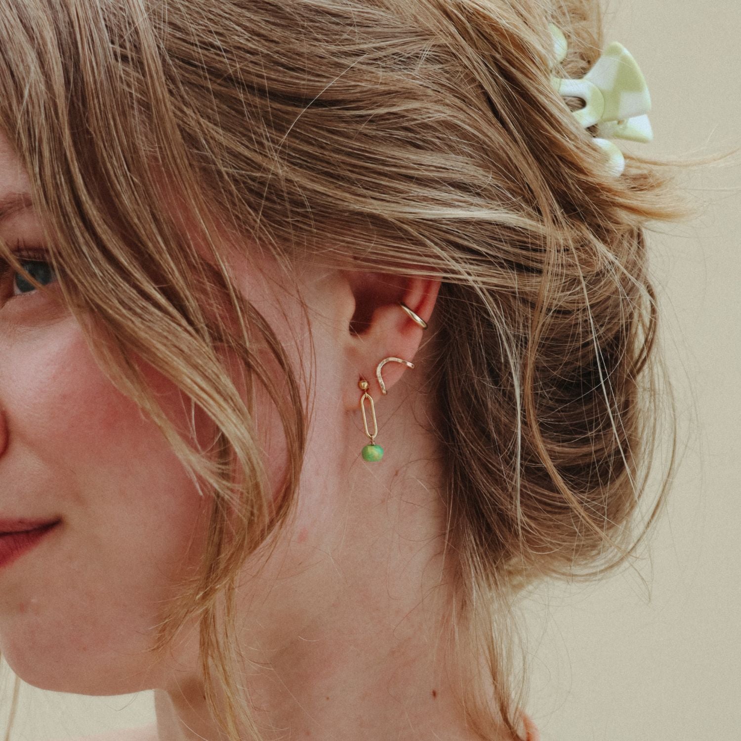 model wearing 14k gold fill stud earrings with turquoise drops paired with other 14k gold fill studs and ear cuff