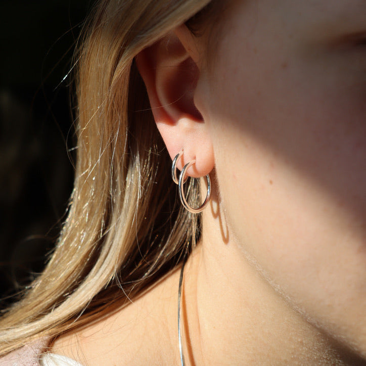 model wearing 2 pair of sterling silver handmade hoop earrings