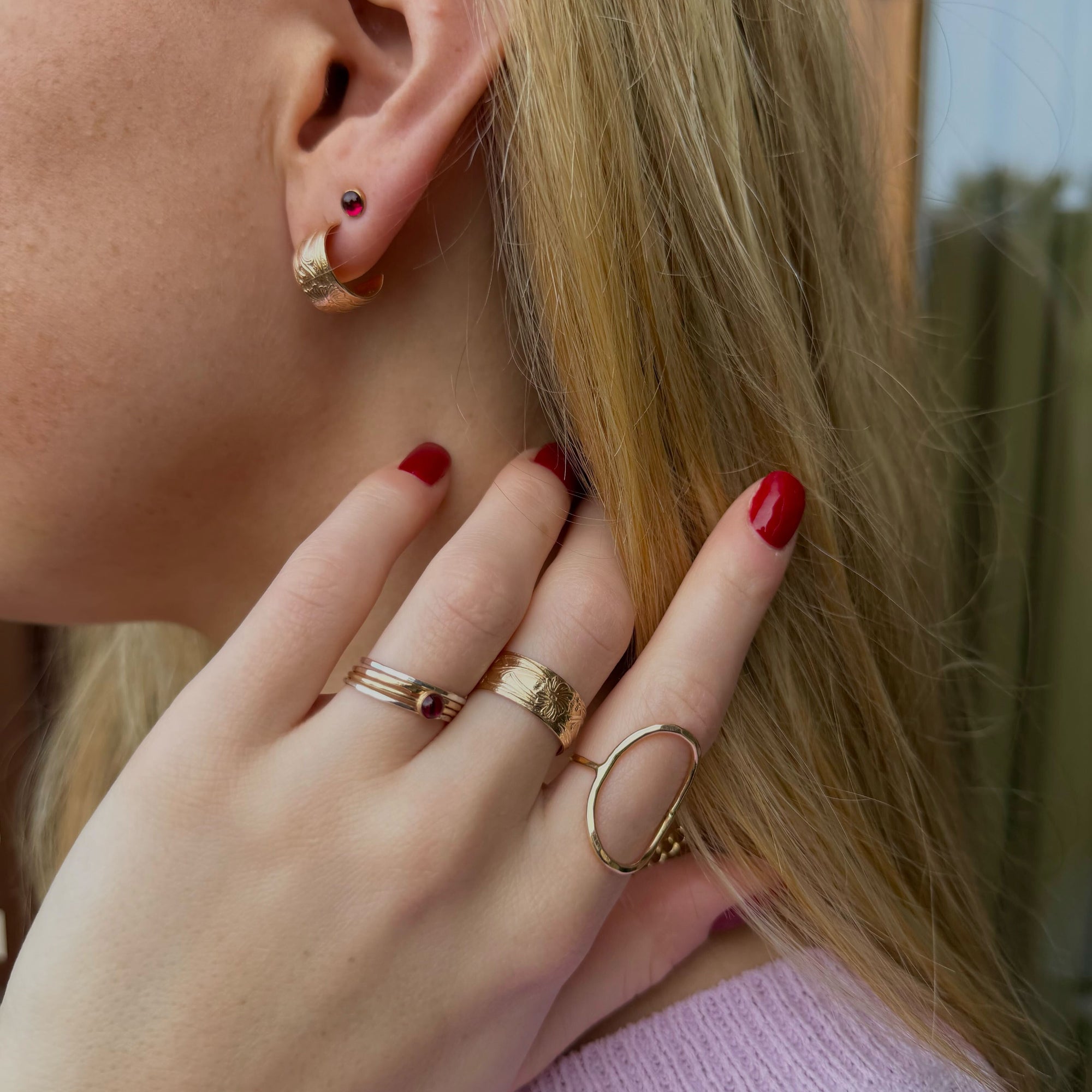 Close-up of model wearing 14k gold fill textured earrings with 14k gold fill textured and hammered rings 