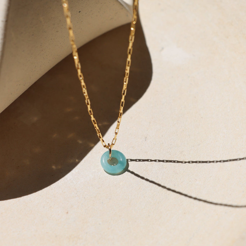 14k gold fill chain necklace with amazonite donut pendant on a light surface