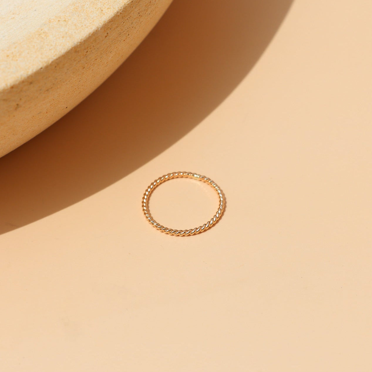 14k gold fill midi ring with a twisted rope band, minimalist stacking design, and delicate everyday style, featuring the Spiral Midi Ring displayed on a ceramic jewelry tray.