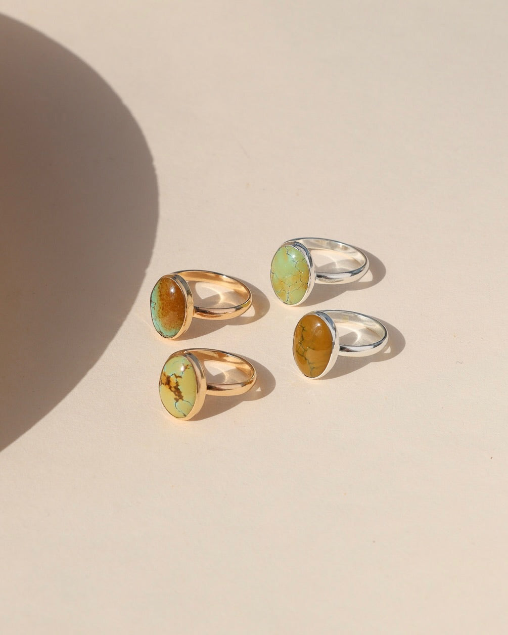 sterling silver and 14k gold fill rings with oval turquoise gemstones in the sunlight