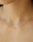 14k gold fill delicate chain, photographed on a brunette model wearing a black t shirt