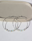 14k gold fill or sterling silver hoops, handmade and lightly hammered for shine, then adorned with six genuine australian opals that are delicately wire-wrapped. Handmade by Token Jewelry in Eau Claire, WI