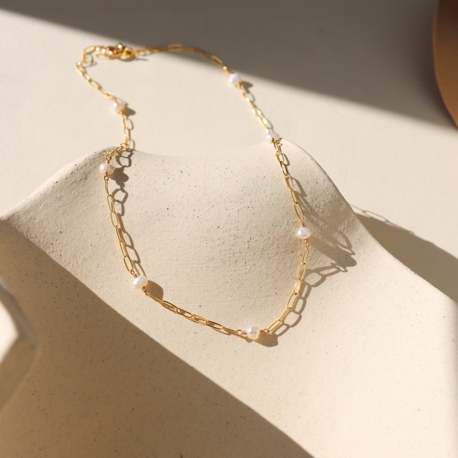 Gold Cosette chain necklace accented with a single lustrous freshwater pearl.