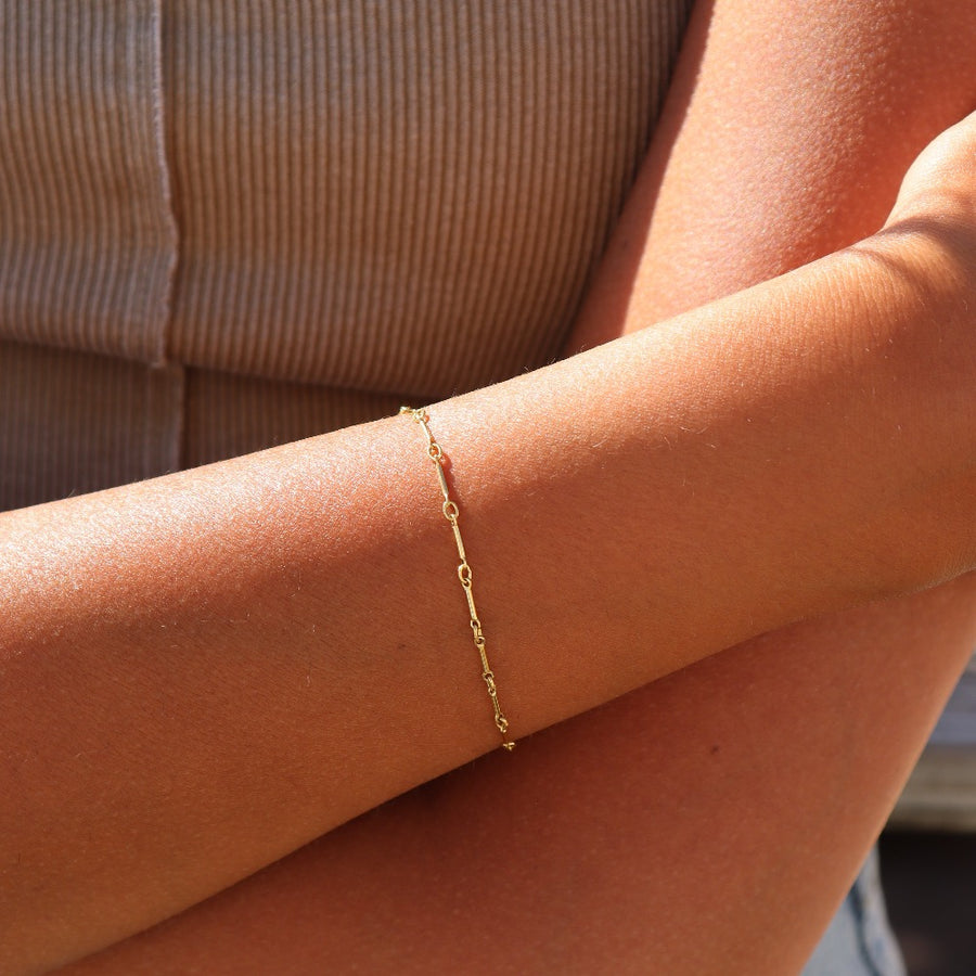 Model wearing 14k gold fill dot + dash bracelet