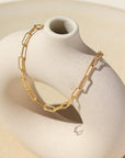 Gold filled piper anklet draped over stone dish