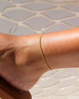 Model wearing 14k gold fill La mer anklet