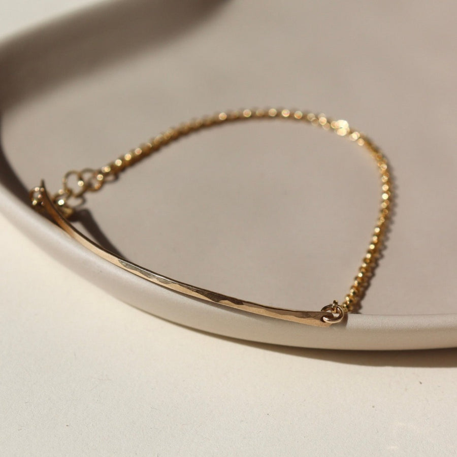 14k gold fill Bar Anklet laid on a tan dish in the sunlight- Token Jewelry