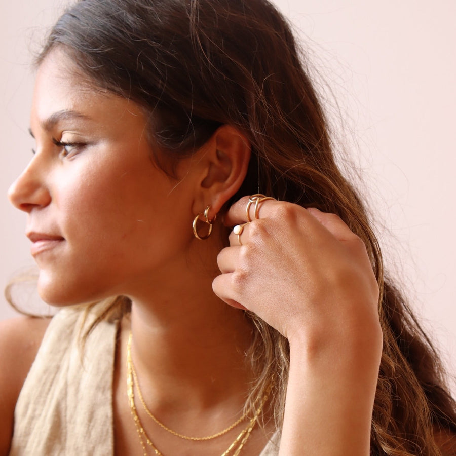 Model wearing 14k gold fill Classic hoops in the classic size as well as the mini size.