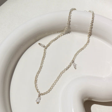 925 Sterling silver Herkimer Anklet laid on a white plate in the sunlight.