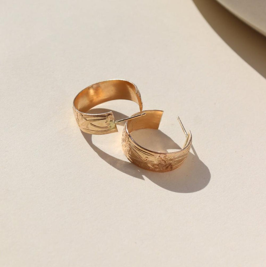 14k gold fill Florence hoops laid on a white plate in the sunlight