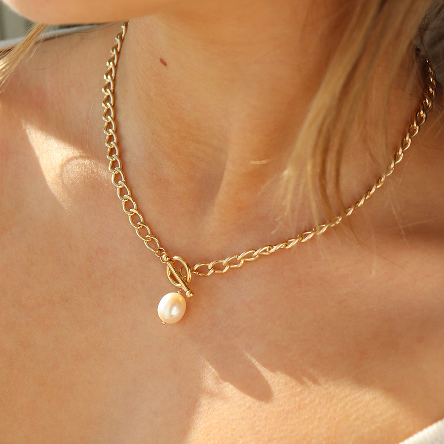 14k gold fill chain with a toggle clasp and large pearl, pictured on a model