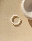 Margot ring laid on a tan plate in the sunlight.