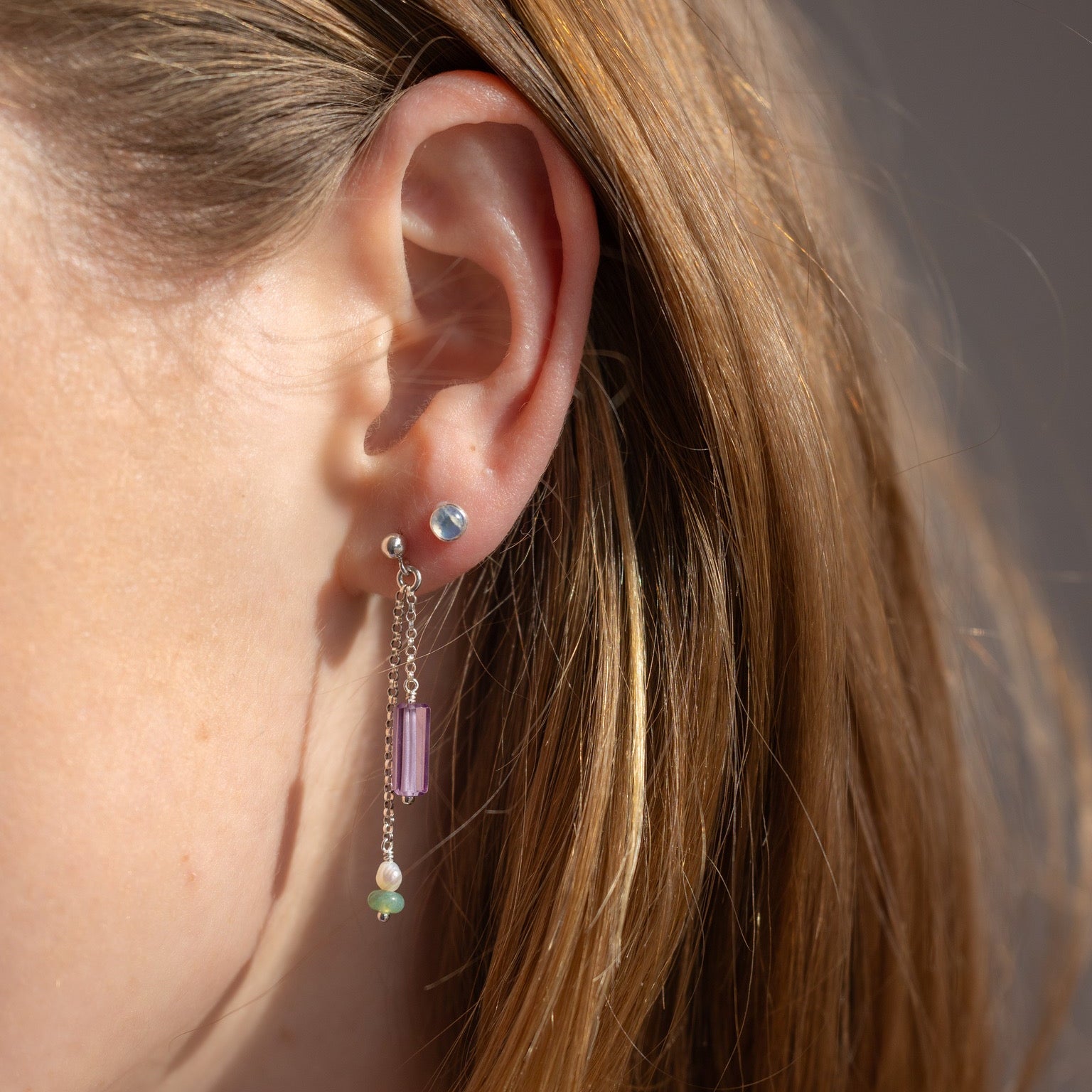 model wearing sterling silver chain drop earrings with gemstone beads