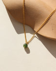 A 14k gold fill small rolo chain featuring a jade ball gemstone. The necklace is displayed on a cream backdrop. 