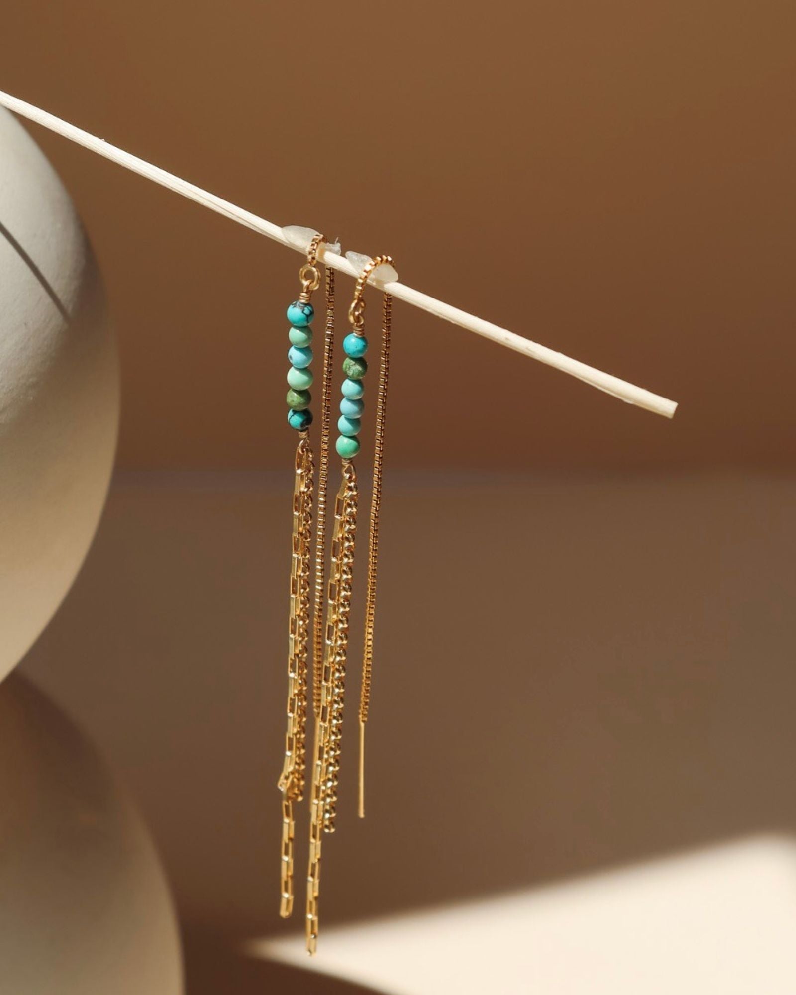 14k gold fill threader style earrings with turquoise beads in the sunlight