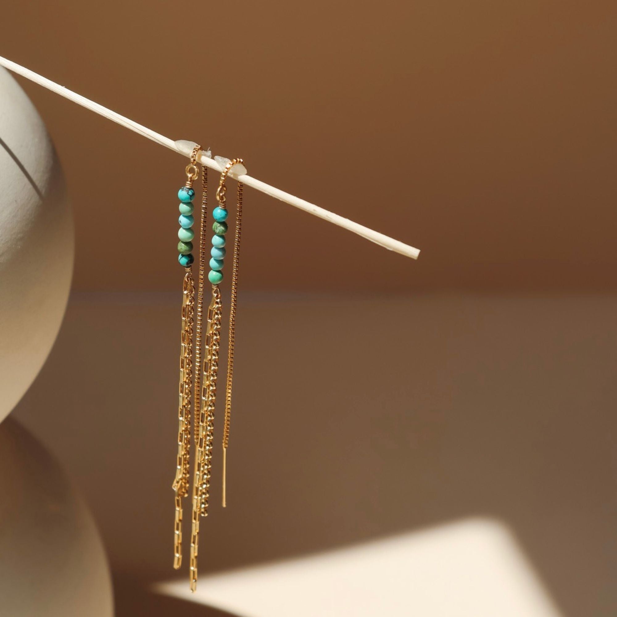 14k gold fill threader style earrings with turquoise beads in the sunlight