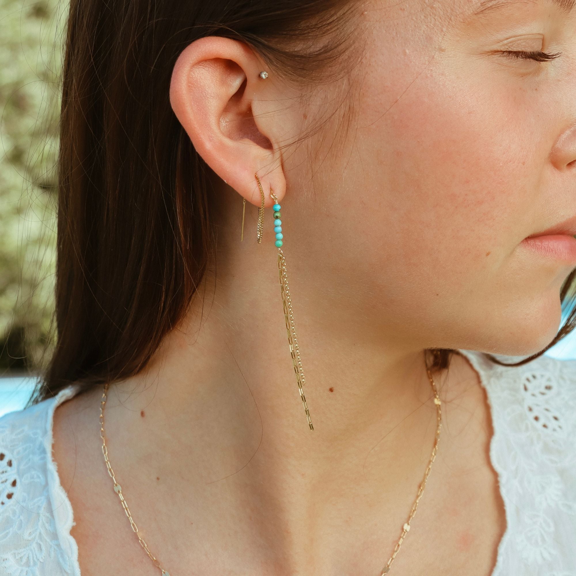 model wearing threader earrings with turquoise stones