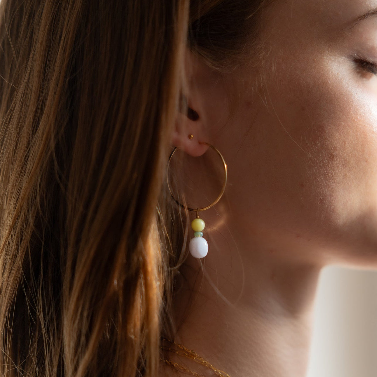 model wearing 14k gold fill hammered hoop earrings with jade and blue lace agate gemstone charms