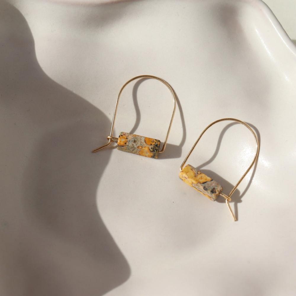 14k gold fill hand shaped arch earrings with leopard jasper stones on a light background