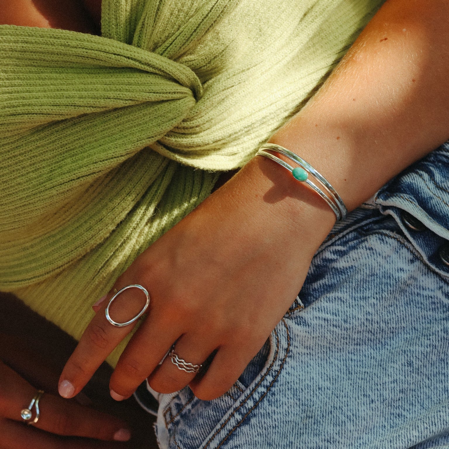 model wearing sterling silver cuff with oval amazonite stone paired with other sterling silver jewelry