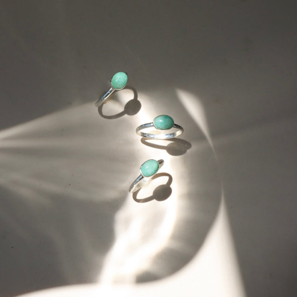 sterling silver rings with oval amazonite stones on a light surface