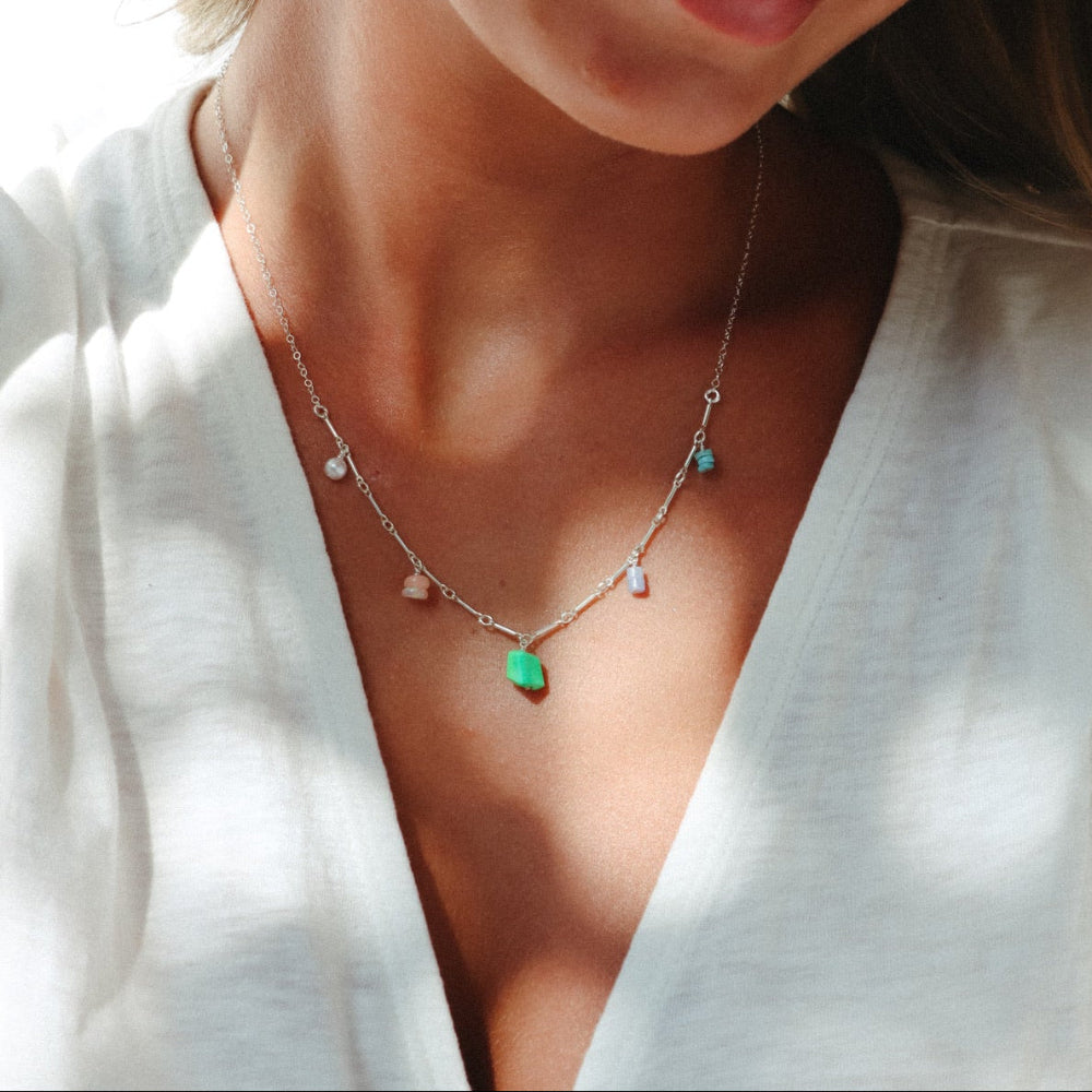 model wearing sterling silver chain necklace with gemstone charms 
