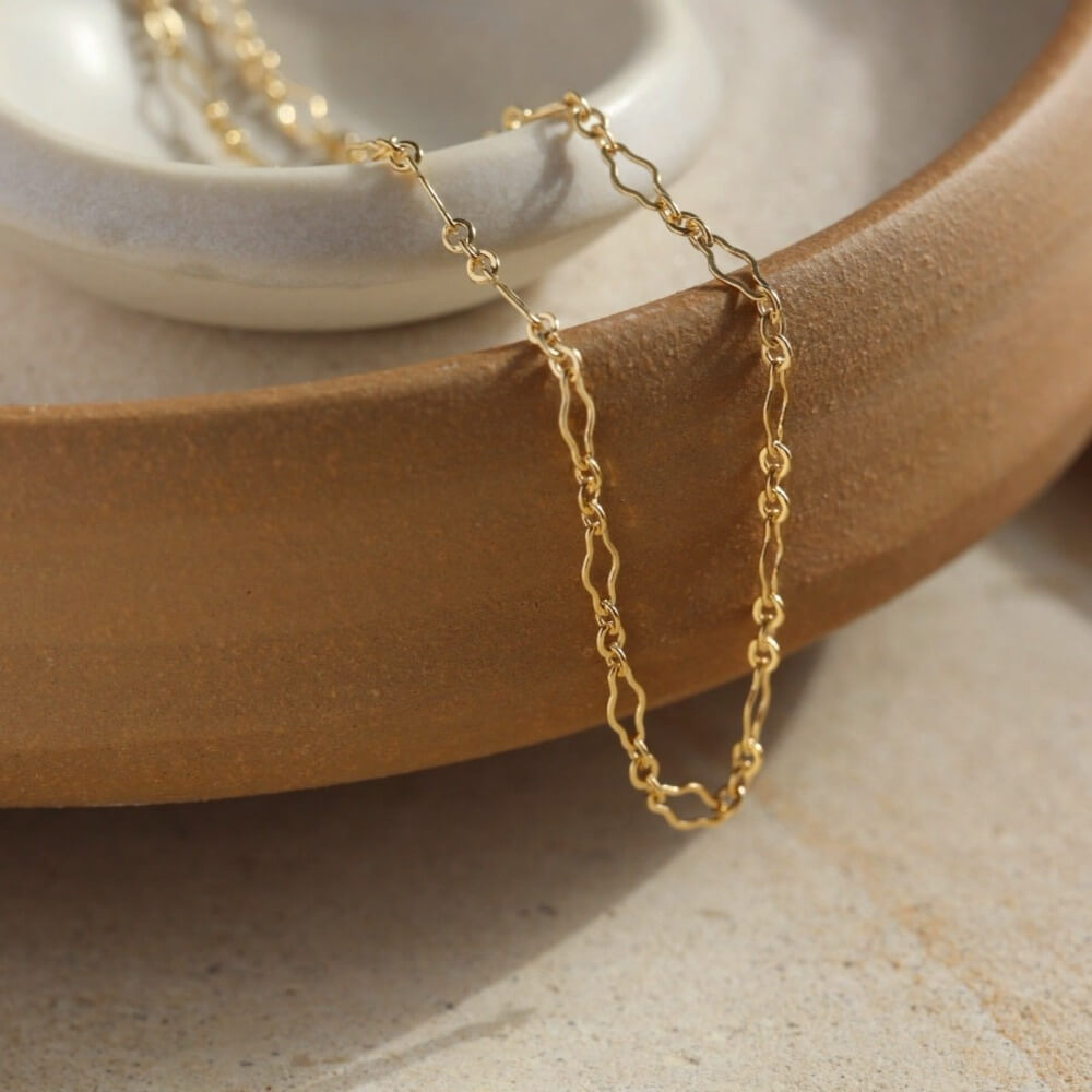 14k gold fill Clara chain on a tan and white jewelry dish in the sunlight