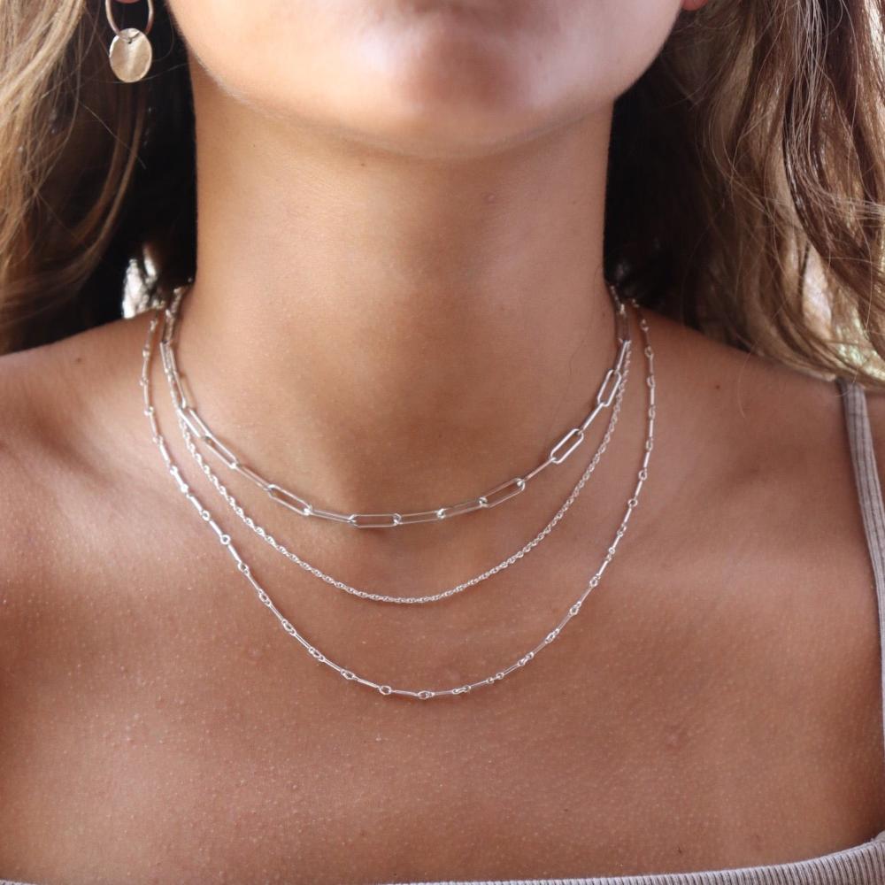 Model wearing 925 sterling silver Gemma chain paired with other chains