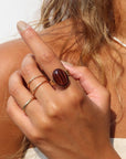 The Scarlett Ring, available in 14k gold fill or sterling silver, features a stunning Red Tiger Eye gemstone on a triple 14k gold fill band