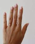 Model wearing spiral midi ring on pointer finger. 