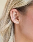 Model wearing a 14k gold fill classic ball post stud with mother of pearl petals surrounding the stud. 