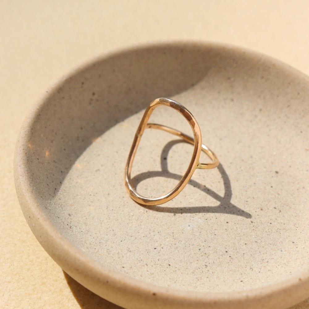 14k gold fill hammered oval ring on a light dish