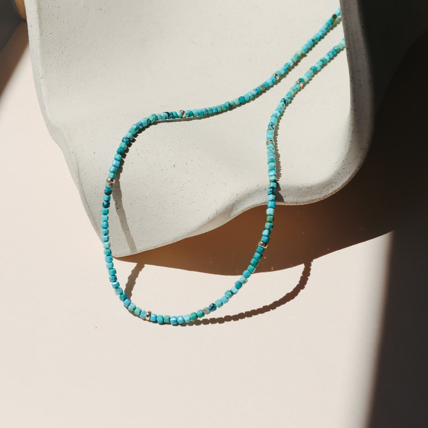 beaded turquoise necklace on a light dish
