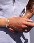 Model wearing a 14k gold fill bracelet with a mixture of Turquoise, Kunzite, Chrysophrase, Serpentine, and Calcedony Gemstones. 