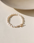 Gold toggle bracelet featuring a strand of lustrous freshwater pearls and a bold circular toggle clasp.