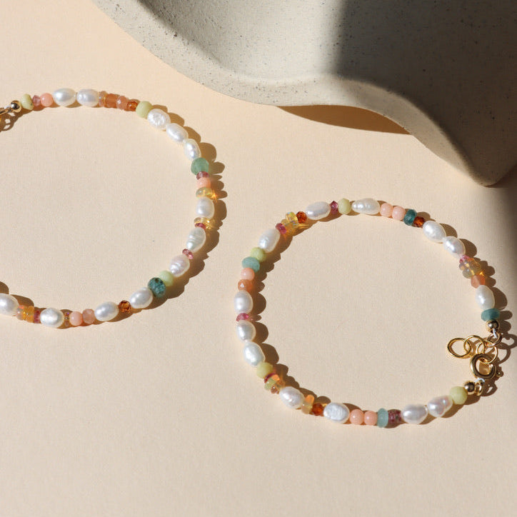 hand beaded bracelet with Pearl, Coral, Opal, Hessenite, Grandidenite, Tourmaline, Moonstone on a light dish