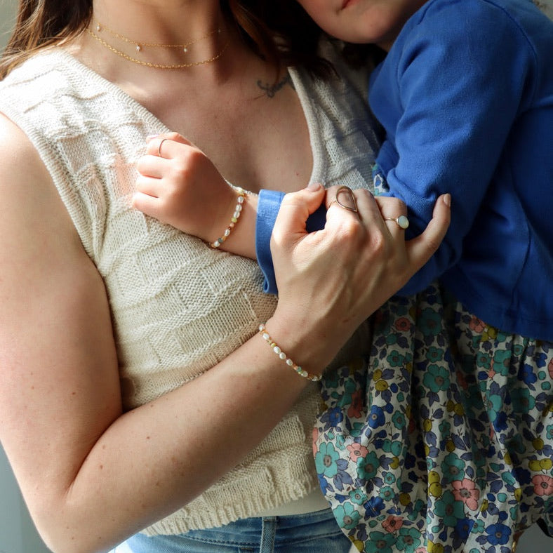 models wearing hand beaded bracelet with Pearl, Coral, Opal, Hessenite, Grandidenite, Tourmaline, Moonstone