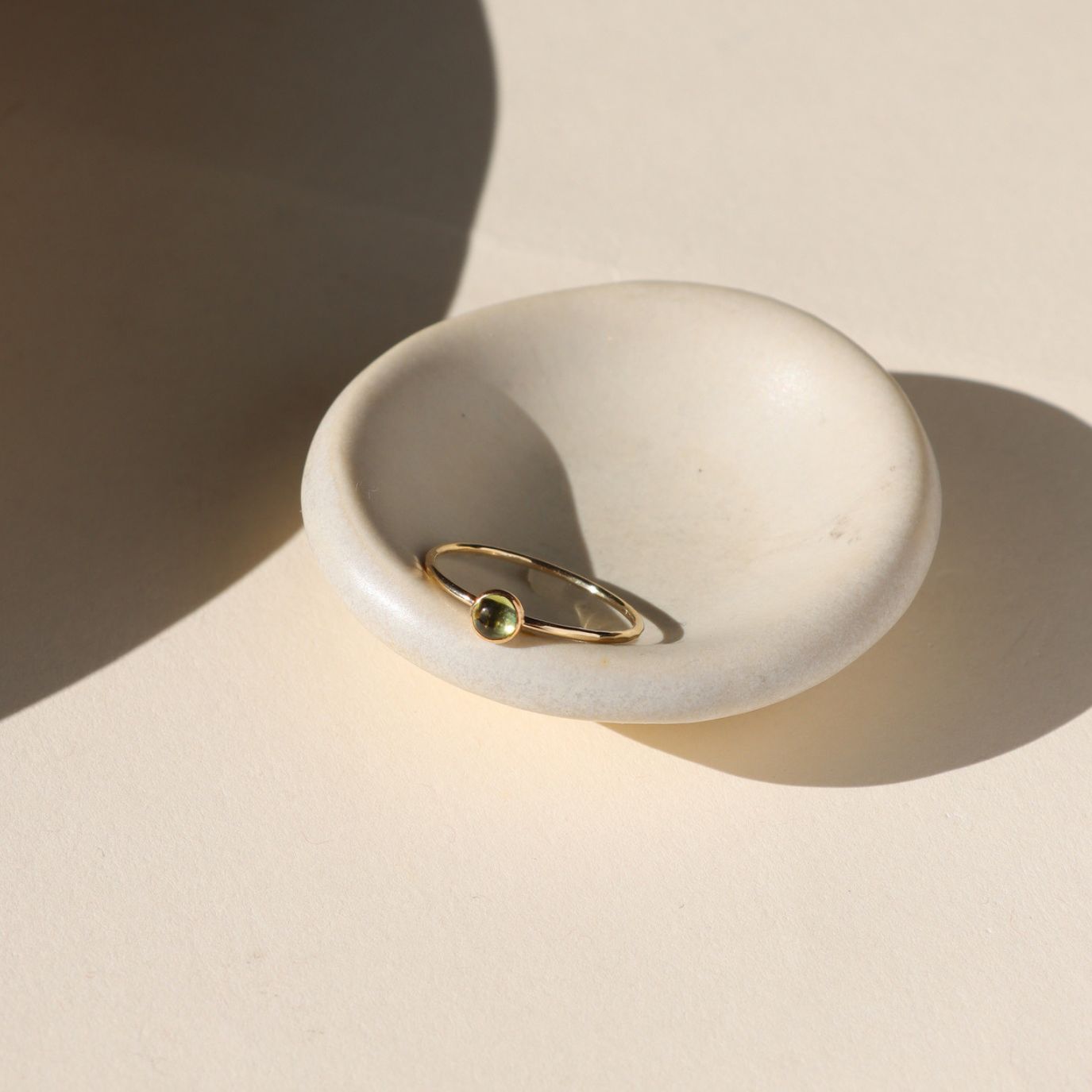 hammered 14k gold fill band ring set with light peridot stone in the sunlight