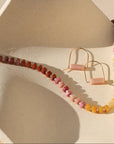 pink opal stones in 14k gold fill arch shaped earrings styled with multi colored stone bead and pearl neckalce in the sunlight