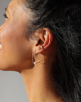 model wearing pink opal stones in sterling silver arch shaped earrings  paired with ear cuff in the sunlight
