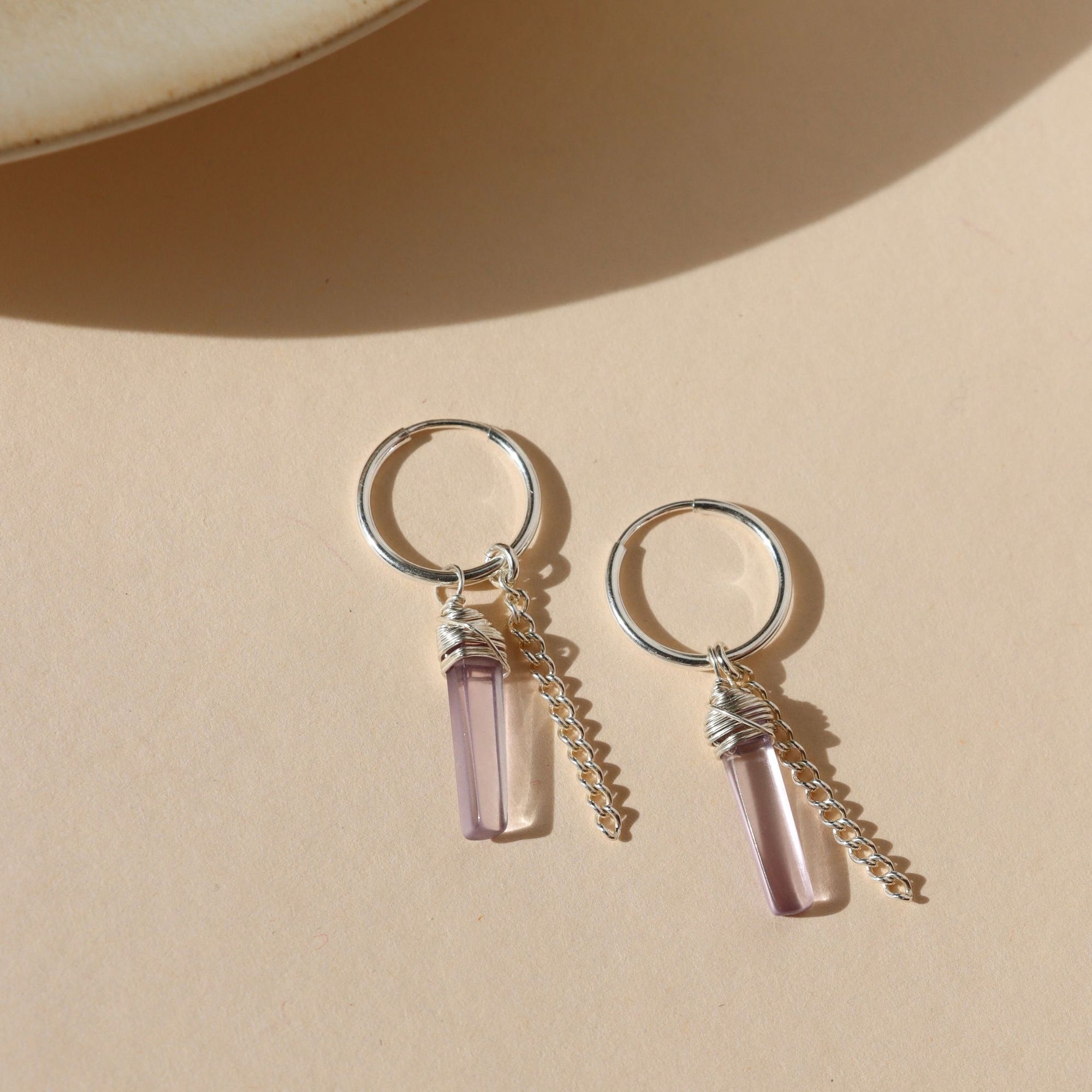 sterling silver hoop earrings with pink amethsyt charms and sterling silver chain on a light background