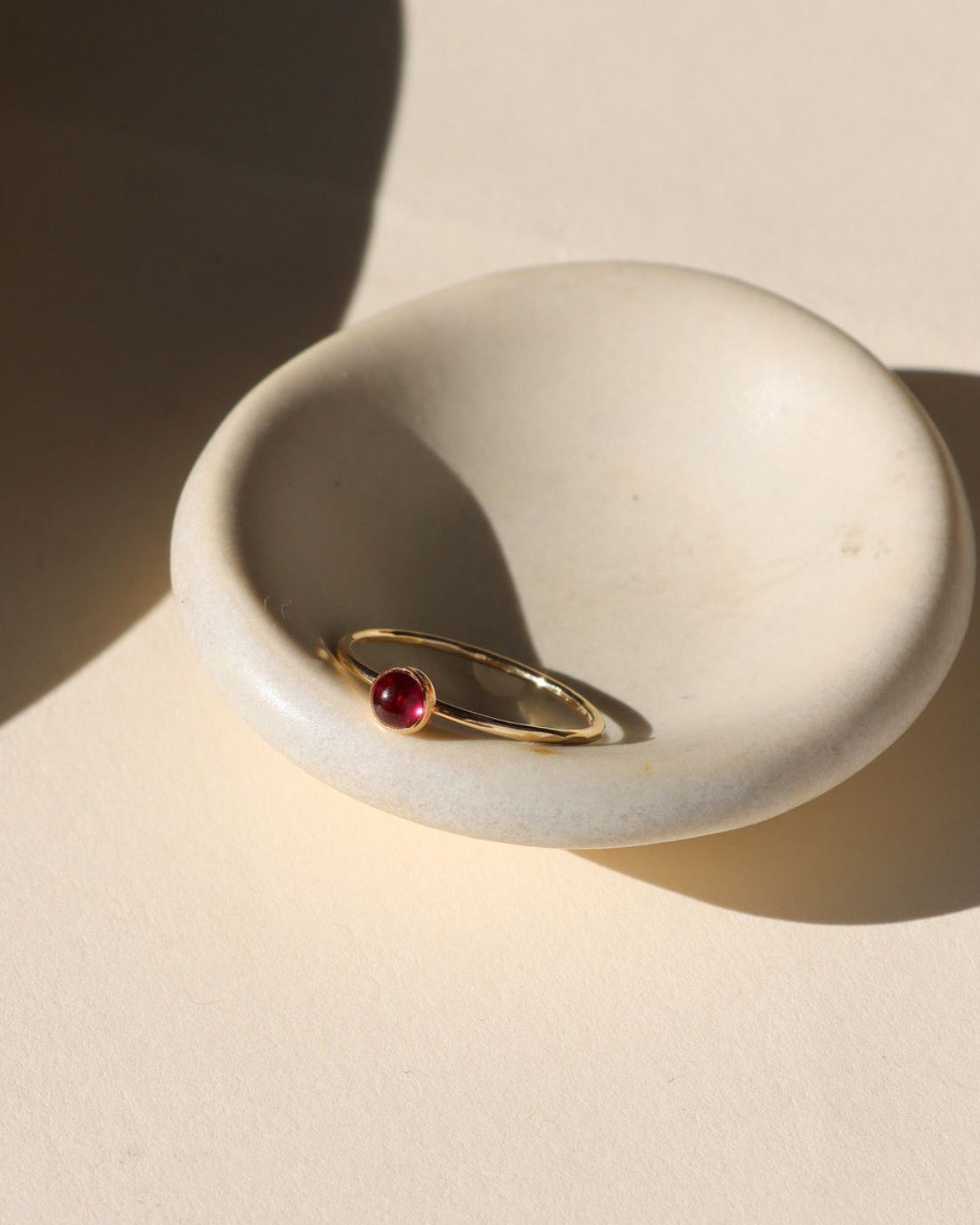 4mm ruby stone set in a 14k gold fill ring setting in the sunlight