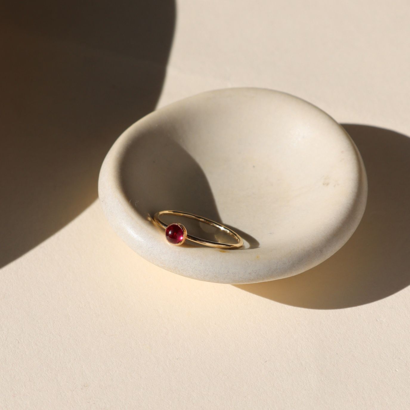 4mm ruby stone set in a 14k gold fill ring setting in the sunlight