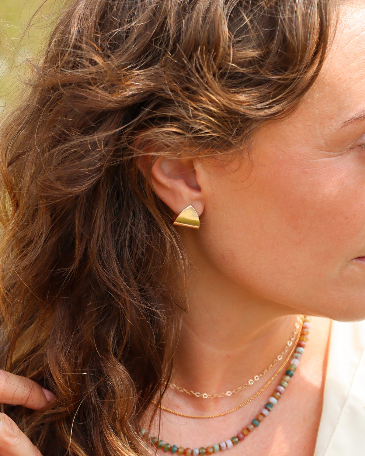 Sculptural folded gold fill stud earrings with a sleek, dimensional silhouette and polished finish.